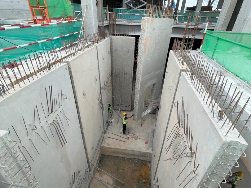 Precast core wall panels being erected around a lift and stair core